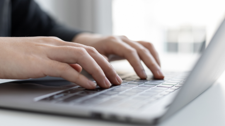 An image of a person writing on a laptop to show how to write a press release.